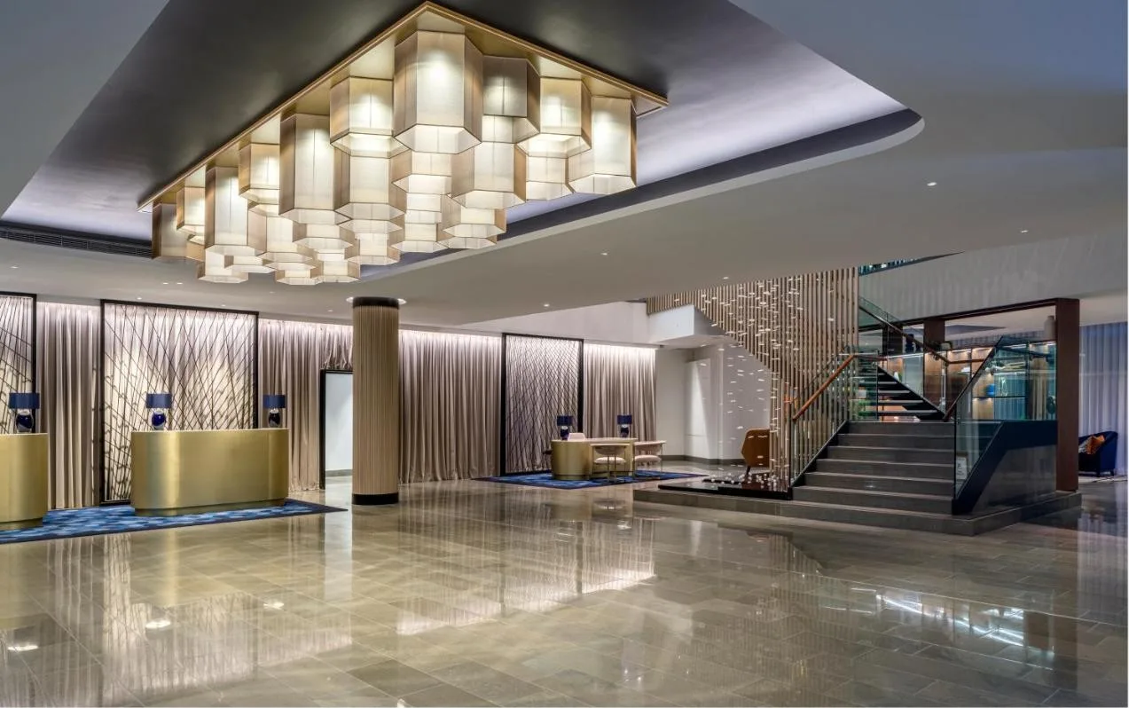 a lobby with a staircase and a chandelier at The Lowry Hotel Manchester in Manchester