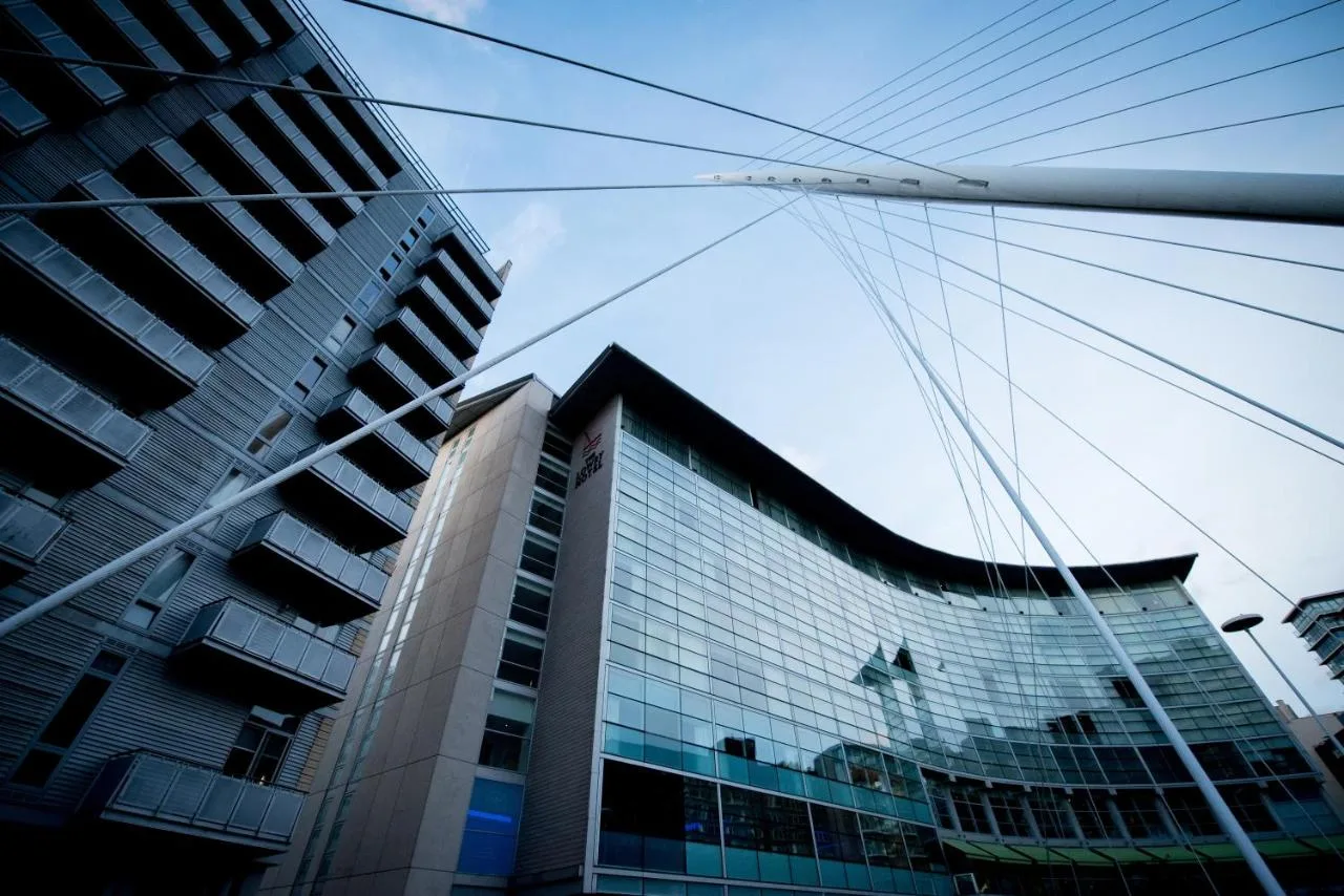 a tall building with glass windows in a city at The Lowry Hotel Manchester in Manchester