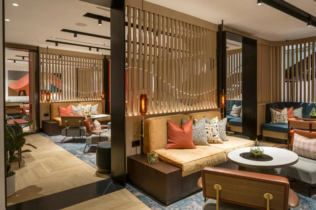 a lobby with a couch and a table and chairs at The Lowry Hotel Manchester in Manchester